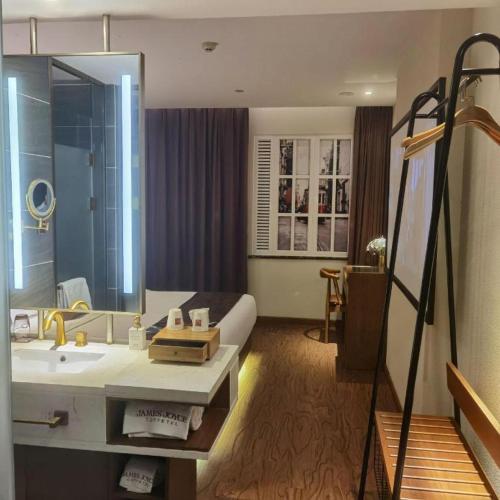 a hotel room with a bathroom with a sink at James Joyce Coffetel·Shijiazhuang Economic and Technological Development Zone Chuangye Road in Shijiazhuang
