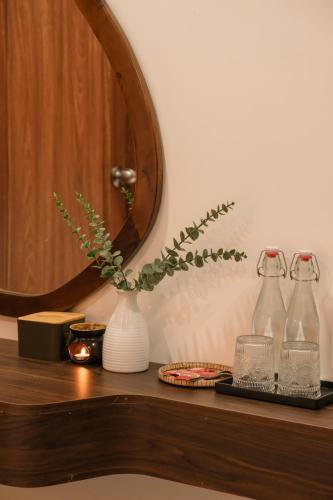 a wooden shelf with a vase and a mirror at Benny Homestay Huế in Hue
