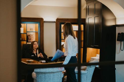 a woman standing in front of a desk in a room at Chateau d'Urspelt in Urspelt