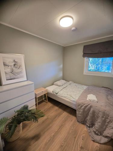 un dormitorio con una cama y una ventana en Nice and spacious apartment in a quiet area, en Tromsø