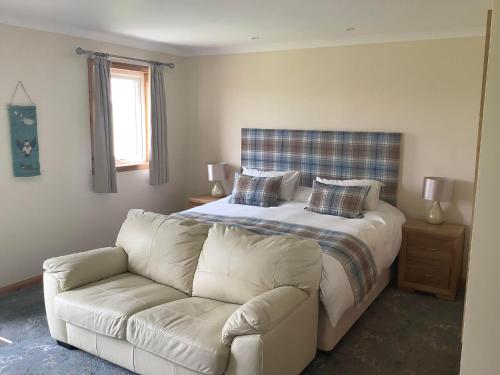 a bedroom with a white bed and a couch at Merkister Hotel in Harray