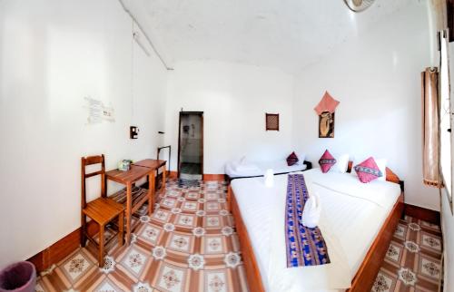 une chambre avec deux lits, une table et un bureau dans l'établissement Vongmany Guesthouse, à Ban Ngoy-Nua