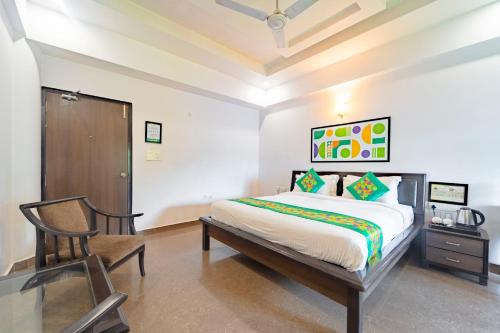a bedroom with a bed and a chair in it at Treebo Shivam Inn Near Singapore Mall in Lucknow