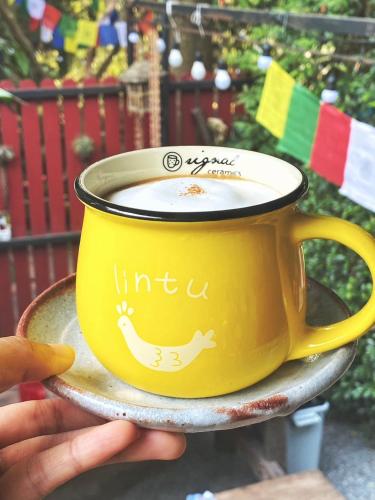 a person holding a cup of coffee on a saucer at Chomklong Experience in Pak Chong