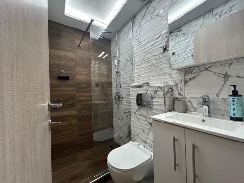 a bathroom with a white toilet and a sink at Dragoumi Suites Lydia in Thessaloniki