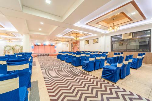 a banquet hall with blue chairs and a dance floor at Treebo Shivam Inn Near Singapore Mall in Lucknow