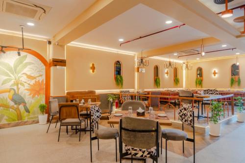 a restaurant with tables and chairs in a room at Treebo Shivam Inn Near Singapore Mall in Lucknow