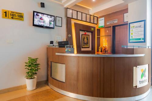 a bar in a hospital lobby with a potted plant at Treebo Shivam Inn Near Singapore Mall in Lucknow