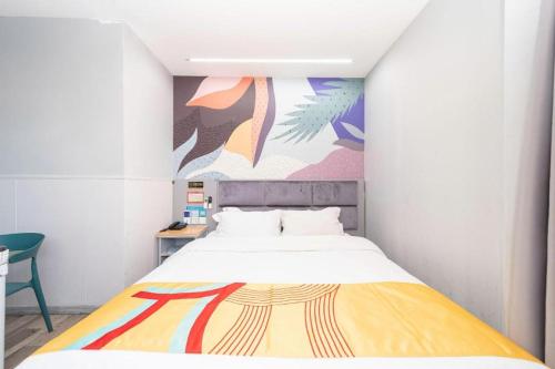 a bedroom with a bed with a painting on the wall at Pai Hotel Xi'an Electronic Zheng Street in Xi'an