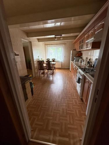 a kitchen and dining room with a table and chairs at Domek pod lasem in Kańczuga