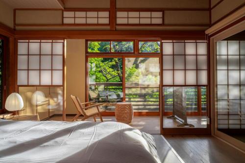 a bedroom with a bed and large windows at プライベートリゾート河津 in Kawazu