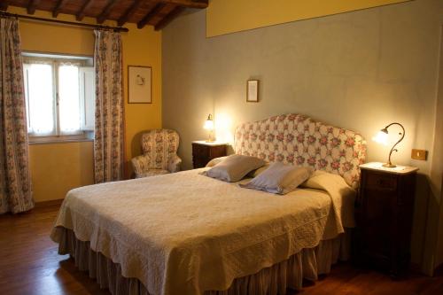 a bedroom with a bed and a chair and a window at Casa Diletta in Massa e Cozzile