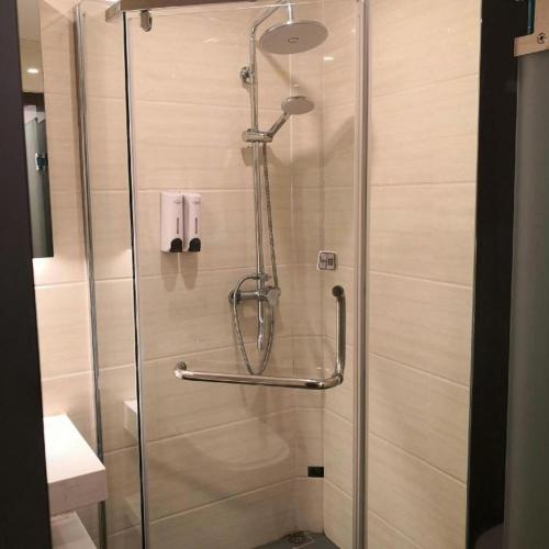 a shower with a glass door in a bathroom at 7 Days Premium Hotel Ji'an Taihe Gongnongbing Avenue in Ji'an