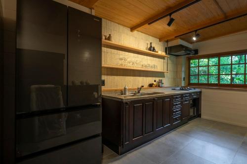 a large kitchen with a sink and a refrigerator at プライベートリゾート河津 in Kawazu