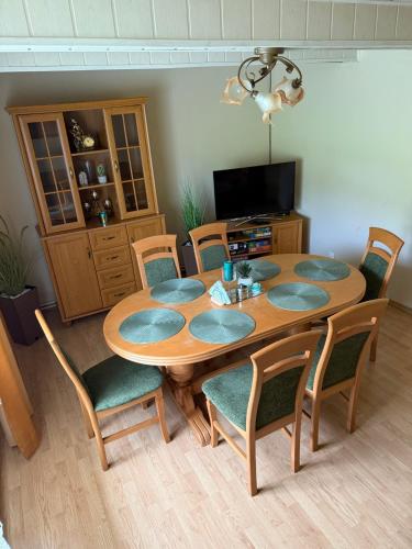 a dining room with a wooden table and chairs at Domek pod lasem in Kańczuga