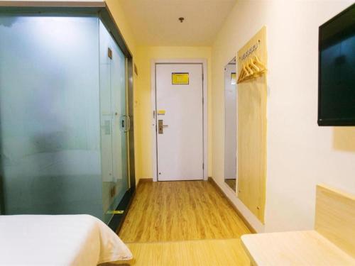 a hallway with a room with a bed and a door at 7 Days Inn Yiyang Shengli Road in Shangrao