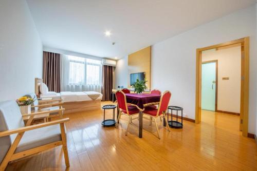 a living room with a table and red chairs at GreenTree Inn Huayin Huashan Town Huashan Scenicspot Express Hotel in Huayin