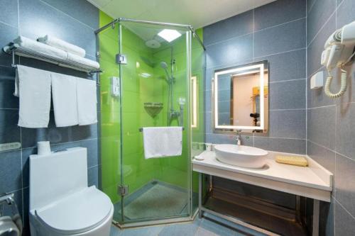 a bathroom with a toilet and a sink and a shower at GreenTree Inn Huayin Huashan Town Huashan Scenicspot Express Hotel in Huayin