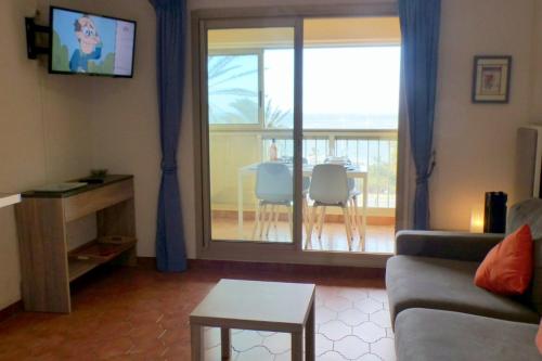 ein Wohnzimmer mit Sofa und Tisch in der Unterkunft Comfortable apartment with pool facing the sea in Six-Fours-les-Plages