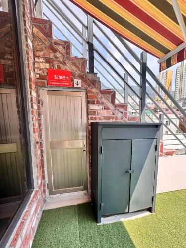 a building with two doors and a brick wall at Terrace Rooftop Luggage Storage Spacious Two Rooms Beam Projector 4 Beds Jeonpo Seomyeon Busan Station in Busan