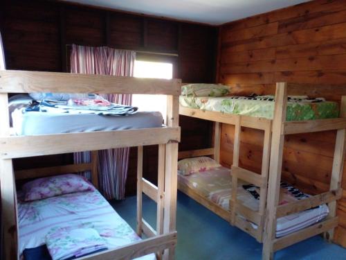 Habitación con 3 literas en una cabaña en Hostel Finisterre, en La Pedrera