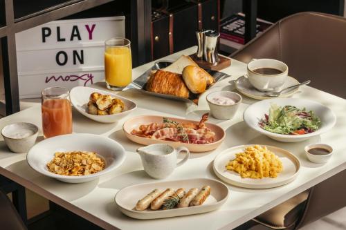 a table with many plates of food on it at Moxy Seoul Myeongdong in Seoul