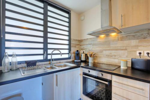 a kitchen with a sink and a counter top at M'Safirina - T2 Saint Paul in Saint-Paul