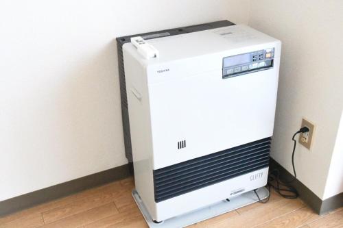 a white machine sitting on the floor next to a wall at Ueda Building - Vacation STAY 8546 in Asahikawa
