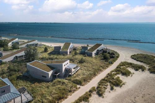 an aerial view of a beach with houses and the ocean at Luxe Villa met Uitzicht 4p - Luxe, Rust & Water - Villa 67 in Ouddorp