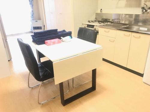 a kitchen with a table with two chairs and a stove at Ueda Building - Vacation STAY 8551 in Asahikawa