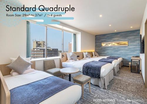 a hotel room with four beds and a window at HOTEL MYSTAYS Kanazawa Katamachi in Kanazawa