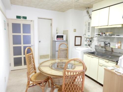 a kitchen with a table and chairs in a kitchen at Ueda Building - Vacation STAY 8554 in Asahikawa