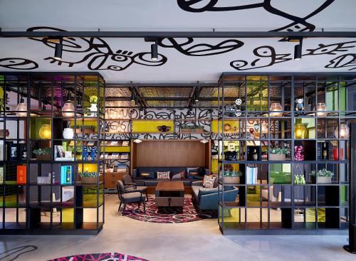 a room with a library with a table and chairs at Moxy Seoul Myeongdong in Seoul