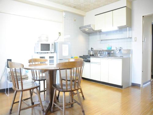 a kitchen with a table and chairs in a room at Ueda Building - Vacation STAY 8563 in Asahikawa