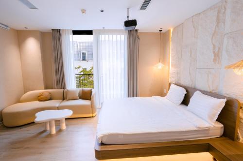 a bedroom with a large bed and a couch at UMEE Homestay in Thôn Trường Giang
