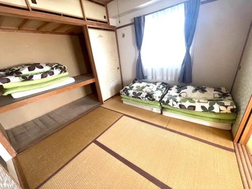 a small room with two beds and a window at Ueda Building - Vacation STAY 8558 in Asahikawa