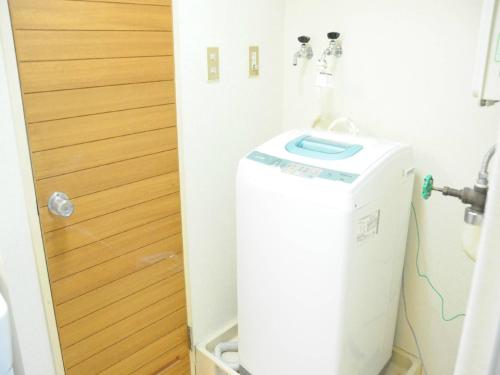 a small refrigerator in a bathroom next to a door at Ueda Building - Vacation STAY 8560 in Asahikawa