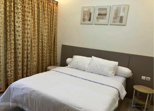 a bed with white sheets and pillows in a bedroom at D'illy Borobudur Villa in Magelang