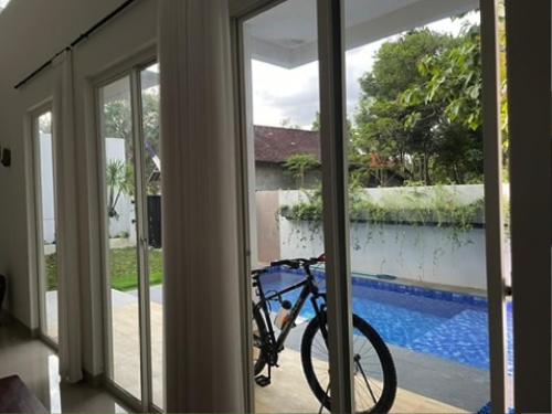 a bike parked in front of a glass door at D'illy Borobudur Villa in Magelang