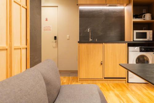 a living room with a couch and a kitchen at winco - Vacation STAY 06660v in Tokyo