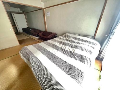 a bedroom with a bed in a small room at Ueda Building - Vacation STAY 8566 in Asahikawa