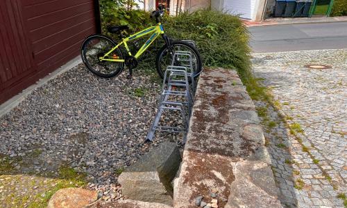 a yellow bike parked next to a bike rack at SB-"PENSION Berggasse" - Gemeinschaftsküche, WIFI, Smart-TV, Zentral! in Olbernhau