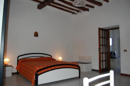 a bedroom with a bed with an orange blanket at Casa Unci in Canneto