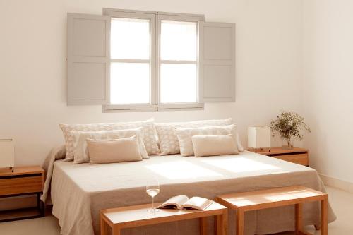 a bedroom with a large bed with a window at Predi Son Jaumell Hotel Rural in Capdepera