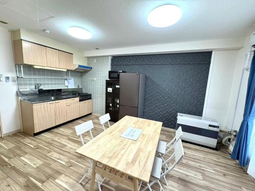 a kitchen with a table and chairs and a refrigerator at Ueda Building - Vacation STAY 17198 in Asahikawa
