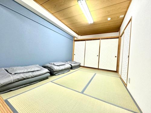 a room with two beds in a room with cabinets at Ueda Building - Vacation STAY 17198 in Asahikawa