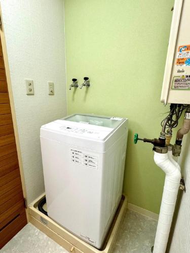 a washer and dryer in a corner of a room at Ueda Building - Vacation STAY 17198 in Asahikawa