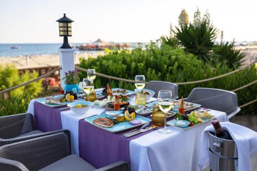 a table with plates of food and glasses of wine at VONRESORT Elite & Aqua - Ultra All Inclusive & Kids Concept in Side