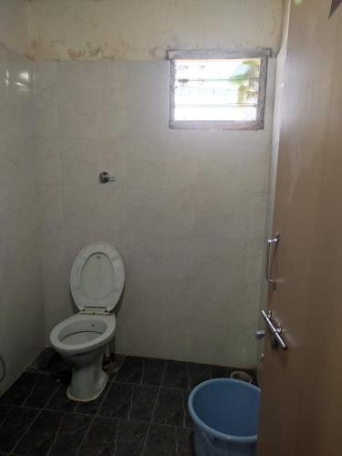 a bathroom with a toilet and a window at HoTEL TANIYA in Vijayawāda