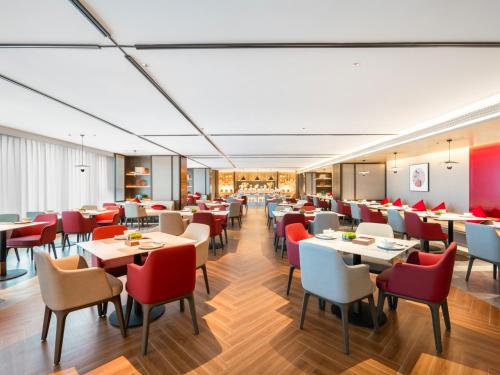 a restaurant with tables and chairs in a room at Guiyang Airport Outlets Yicheng Hotel 